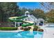 The community pool is resort-like with a slide, clubhouse, chairs and lush landscaping at 5424 Landsdowne Ct, Cumming, GA 30041