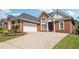 Charming brick home features a two-car garage and beautiful landscaping at 5832 Sloane St, Douglasville, GA 30135