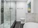 Modern bathroom features a glass enclosed shower with gray hexagon tile accent wall and dark wood floors at 3423 Rugby Cir, Atlanta, GA 30337