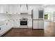 Bright white kitchen features stainless appliances, farmhouse sink and modern fixtures at 3423 Rugby Cir, Atlanta, GA 30337