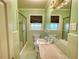 Bathroom showing the sink, toilet, tub and shower with green tile and neutral countertops at 2520 Overlook Ne Way, Atlanta, GA 30345