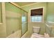 Bathroom showing the toilet, tub and shower with green tile and neutral countertops at 2520 Overlook Ne Way, Atlanta, GA 30345