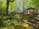 Quaint home with lush landscaping, brick facade, and a gambrel roof design on a wooded lot at 2520 Overlook Ne Way, Atlanta, GA 30345