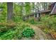 Beautiful brick home surrounded by lush greenery, featuring a stone pathway leading to the entrance at 2520 Overlook Ne Way, Atlanta, GA 30345