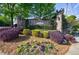 Stone monument sign at the community entrance with vibrant landscaping and mature trees at 3250 Twisted Branches Ln, Marietta, GA 30068