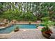 Backyard pool with brick surround, lush landscaping, and mature trees at 3250 Twisted Branches Ln, Marietta, GA 30068