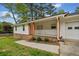 Inviting front porch features brick steps, wood pillars, and a white railing, enhancing curb appeal at 3451 Birchwood Trl, Snellville, GA 30078