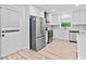 Well-lit kitchen featuring a stainless steel refrigerator, and a view through the window to the outdoors at 3451 Birchwood Trl, Snellville, GA 30078