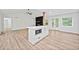 Open living space featuring light wood floors, a central island with a microwave, and a fireplace feature wall at 3451 Birchwood Trl, Snellville, GA 30078