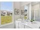 A vanity in the bathroom has a large mirror and a bright window with a neighborhood view at 3698 Annsbury Ct, Lilburn, GA 30047
