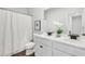 Bright bathroom featuring double sink vanity, white cabinets, and a shower with white curtain at 3698 Annsbury Ct, Lilburn, GA 30047