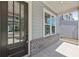 Welcoming front porch featuring brick accents, a gray siding exterior, and a glass front door at 3698 Annsbury Ct, Lilburn, GA 30047