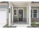 Inviting front porch with brick accents, sturdy columns, and a glass-paneled front door at 3698 Annsbury Ct, Lilburn, GA 30047