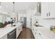 Spacious kitchen featuring white cabinets, stainless steel appliances, and a view into the dining area at 3698 Annsbury Ct, Lilburn, GA 30047