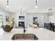 Open floor plan with kitchen island overlooking living and dining areas, modern light fixtures, and fireplace at 3698 Annsbury Ct, Lilburn, GA 30047