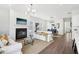 Open-concept living area with fireplace, stylish light fixtures, and seamless flow to the dining space at 3698 Annsbury Ct, Lilburn, GA 30047