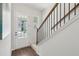 Staircase with hardwood floors, iron railings, and a view of the front door and exterior at 3698 Annsbury Ct, Lilburn, GA 30047