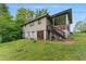 Backyard view showing the house foundation, porch with stairs, and surrounding greenery at 5335 Old Floyd Sw Rd, Mableton, GA 30126
