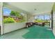 Enclosed porch with outdoor furniture and green carpet, offering a relaxed space at 5335 Old Floyd Sw Rd, Mableton, GA 30126