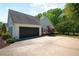 Charming house featuring an attached garage and a paved driveway, all surrounded by lush trees and landscaping at 7375 Cavaletti Cir, Cumming, GA 30040
