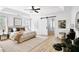 Spacious main bedroom with tray ceilings, a ceiling fan, and a sliding barn door leading into the bathroom at 7375 Cavaletti Cir, Cumming, GA 30040