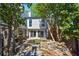Rear exterior view showcases a patio with a stone fireplace, water feature, and sliders at 1009 Riverbend Club Se Dr, Atlanta, GA 30339
