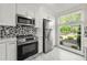 Bright kitchen featuring stainless steel appliances, mosaic backsplash, and a large window with a view at 1009 Riverbend Club Se Dr, Atlanta, GA 30339