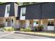Charming townhome featuring brick facade, well-maintained landscaping, and black shingle roofing at 5180 Chemin De Vie, Atlanta, GA 30342