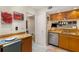 Kitchen featuring stainless dishwasher, granite counters, and light wood cabinets at 5180 Chemin De Vie, Atlanta, GA 30342