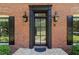 Elegant front door with black trim, brick facade, and stylish exterior lighting at 5790 Heards Forest Dr, Atlanta, GA 30328