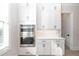 White kitchen with built-in oven, bright light, and custom cabinet storage at 255 Briscoe Way # 5, Alpharetta, GA 30009