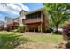 Back exterior of a brick townhome with covered porch and fenced yard, great for outdoor enjoyment at 4201 Village Green Dr, Roswell, GA 30075
