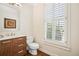 Stylish powder room features modern vanity, wood floors, elegant fixtures, and plantation shutters at 4201 Village Green Dr, Roswell, GA 30075