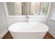 Bright bathroom featuring freestanding tub with chrome fixtures and white tile backsplash at 4201 Village Green Dr, Roswell, GA 30075