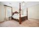Bedroom featuring a four-poster bed, neutral walls, carpet, and bright window at 4201 Village Green Dr, Roswell, GA 30075
