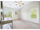 Bedroom featuring neutral walls, carpet, and a ceiling fan is lit by two windows at 4201 Village Green Dr, Roswell, GA 30075