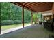 View of the covered patio and wooded backyard, perfect for outdoor entertaining and relaxation at 4201 Village Green Dr, Roswell, GA 30075
