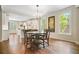 Bright dining area features hardwood floors and windows offering natural light and flows into a modern, white kitchen at 4201 Village Green Dr, Roswell, GA 30075