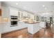 Modern kitchen with white cabinets, stainless steel appliances, and a center island, open to dining area at 4201 Village Green Dr, Roswell, GA 30075
