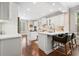 Spacious white kitchen features stone countertops, a tile backsplash, a breakfast bar, and hardwood floors at 4201 Village Green Dr, Roswell, GA 30075