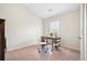 A home office features neutral walls and carpet, with a desk and chair at 4201 Village Green Dr, Roswell, GA 30075