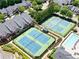 Aerial view of the community tennis courts and pool area surrounded by lush landscaping and well-maintained townhomes at 4201 Village Green Dr, Roswell, GA 30075