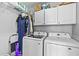 Functional laundry room with modern appliances, overhead cabinets, and hanging rack at 1325 Richland Creek Ct, Sugar Hill, GA 30518