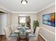 Open dining area with hardwood floors, a glass table, and stylish decorations at 1444 Bridgewater Br, Stone Mountain, GA 30088