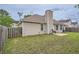 Backyard featuring an open green space, a wooden fence, and the exterior of the house with a chimney at 4719 Score Ct, Snellville, GA 30039