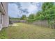 Backyard with a well-maintained lawn, a wooden fence, and a view of the home's exterior at 4719 Score Ct, Snellville, GA 30039