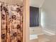Bathroom featuring a shower with a patterned curtain and a soaking tub with a gray window shade at 4719 Score Ct, Snellville, GA 30039