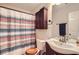 Bathroom featuring striped shower curtain, vanity with sink, and a mirrored wall in a well-lit space at 4719 Score Ct, Snellville, GA 30039