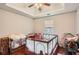 Bright bedroom with hardwood floors and tray ceiling, shown with furniture and natural light from the window at 4719 Score Ct, Snellville, GA 30039