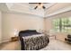 Inviting bedroom with a tray ceiling, comfortable bed, and sunny windows overlooking the yard at 4719 Score Ct, Snellville, GA 30039